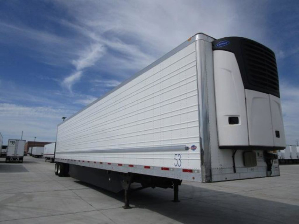 Refrigerated trailer with a white box body and a cooling unit on front corner; side shows aluminum panels and a few markings.