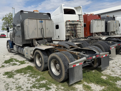 Peterbilt 389 UltraCab tractor rear view showing chassis and dual rear axles with exposed air tanks and brackets.