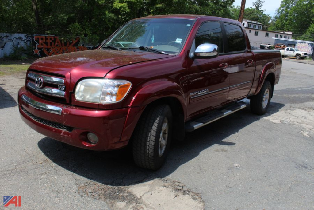 Toyota Tundra crew cab pickup truck in maroon with chrome side mirrors and running boards, front three-quarter view.