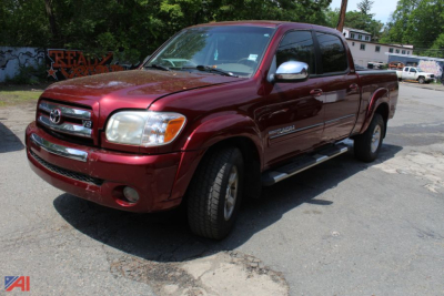 Toyota Tundra crew cab pickup truck in maroon with chrome side mirrors and running boards, front three-quarter view.