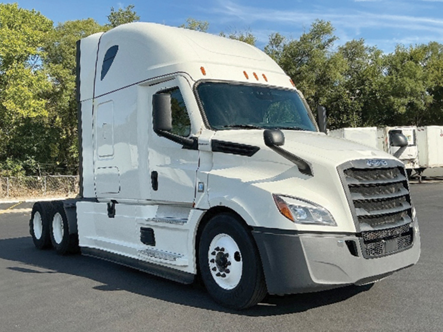 Truck cab exterior of a white Freightliner Cascadia 126 roof sleeper with aerodynamic mirrors and black grille.