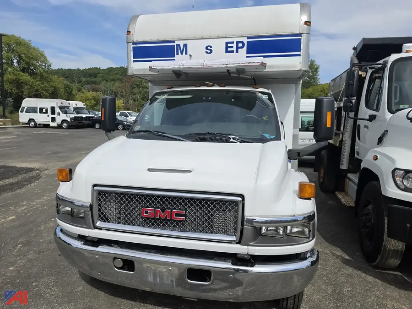 GMC 2008 C4 4500 medium duty mobile lab truck front view with cab white, chrome grille, and raised periodic body on top.