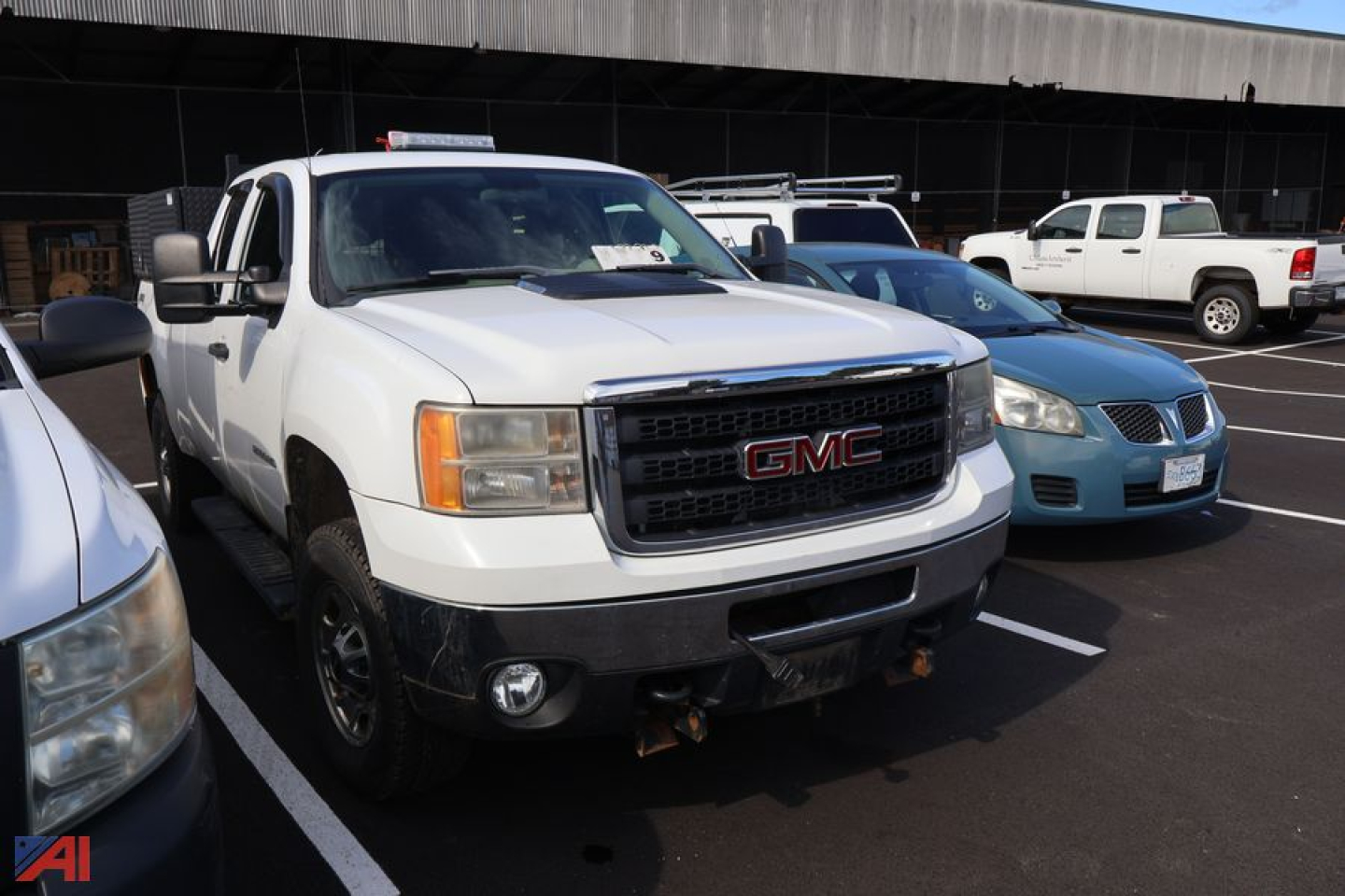 GMC Sierra 2500 pickup truck front view showing GMC grille and bumper in a parking lot.