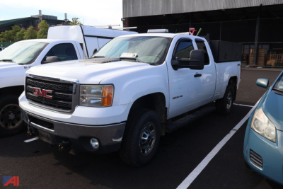 GMC Sierra 2500 pickup truck in white, front three-quarter view, in a parking lot; badge shows GMC grille and 4x4 badge on side.