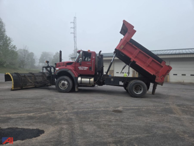 International WorkStar 7500 dump truck with raised bed, side view, red cab and dump body, logo and equipment on yard surface.