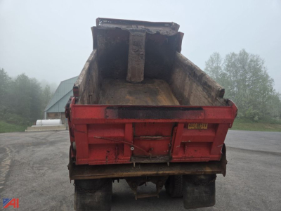 Dump truck bed of an International WorkStar 7500 showing large open-bed with dirt and rust-free surface, rear view, red dump body.