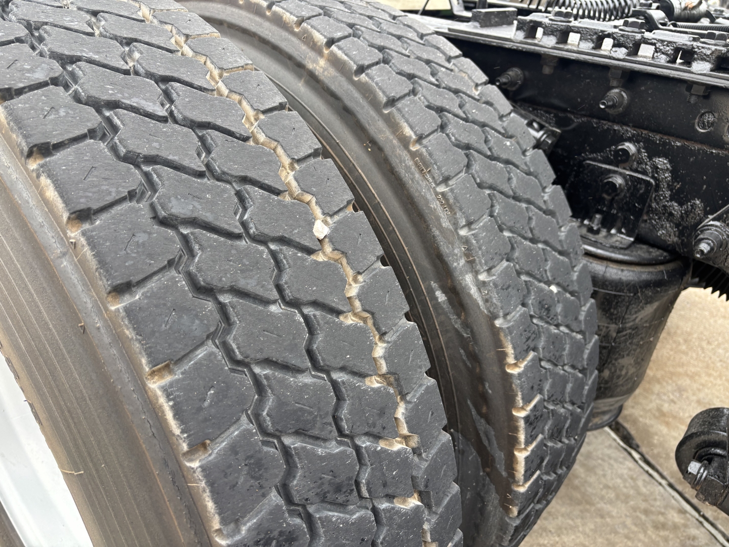 Truck chassis and dual rear tires showing tread and wheel area near the suspension.