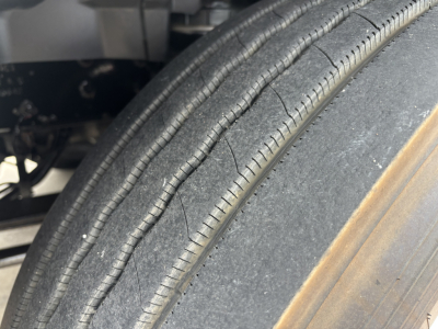 Tire tread close-up on a 2019 International LT truck, showing a single front tire with visible wear and a metal rim edge.