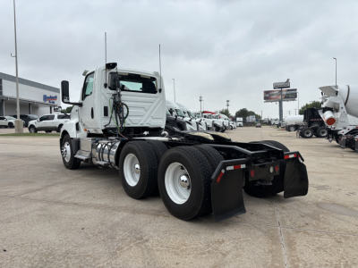 Truck chassis of a 2019 International LT daycab showing rear dual-axle configuration with mudflaps and fifth-wheel/rigid frame. Visible components include fuel tanks and exhaust piping near the cab.