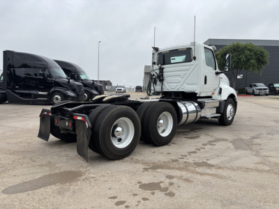2019 International LT truck chassis rear angled view showing dual rear axles, white cab, black fuel tanks, and equipment mounts.