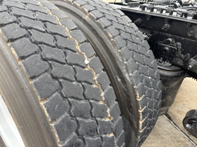 Truck chassis and dual rear tires showing tread and wheel area near the suspension.