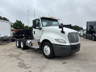 2019 International LT conventional daycab tractor showing front-left angle, with white cab, black bumper, and dual rear axles. Visible text includes International badge on grille and LT model near headlight, and chrome fuel tanks.
