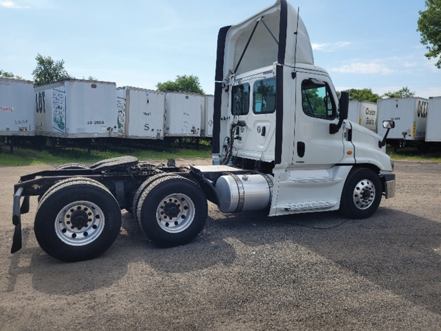 Freightliner Cascadia Evolution 2019 side view showing tractor chassis and cab with sleeper crest, white exterior, rear dual axles and fuel tanks.