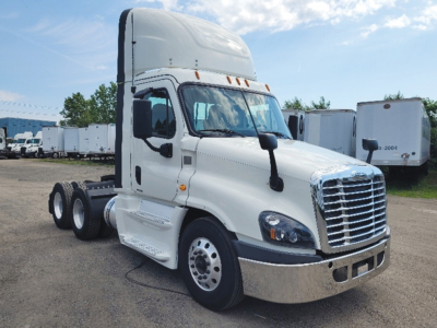 Truck cab showing 2019 Freightliner Cascadia Evolution in white with sleeper high roof, front chrome grille, dual rear axles, daytime running lights, and large side mirrors.
