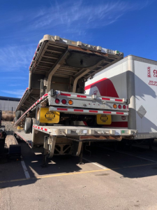 Trailer hydraulic ramp on a drop deck trailer showing Trail King Tk80acs-34 markings and rear lights.