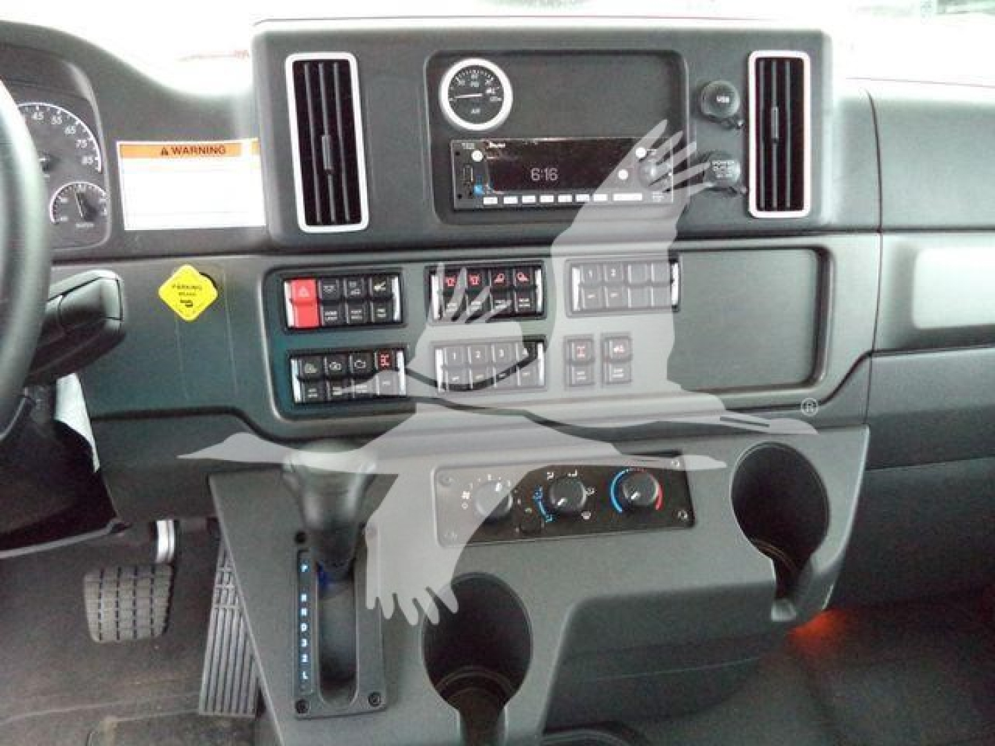 Dashboard view of a Freightliner M2 106 cabin showing center console with gauges, climate controls, and cup holders.