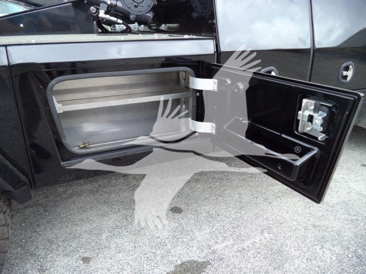 Truck side storage compartment with open door showing empty rectangular cavity and latch; Freightliner M2 106 exterior panels visible.