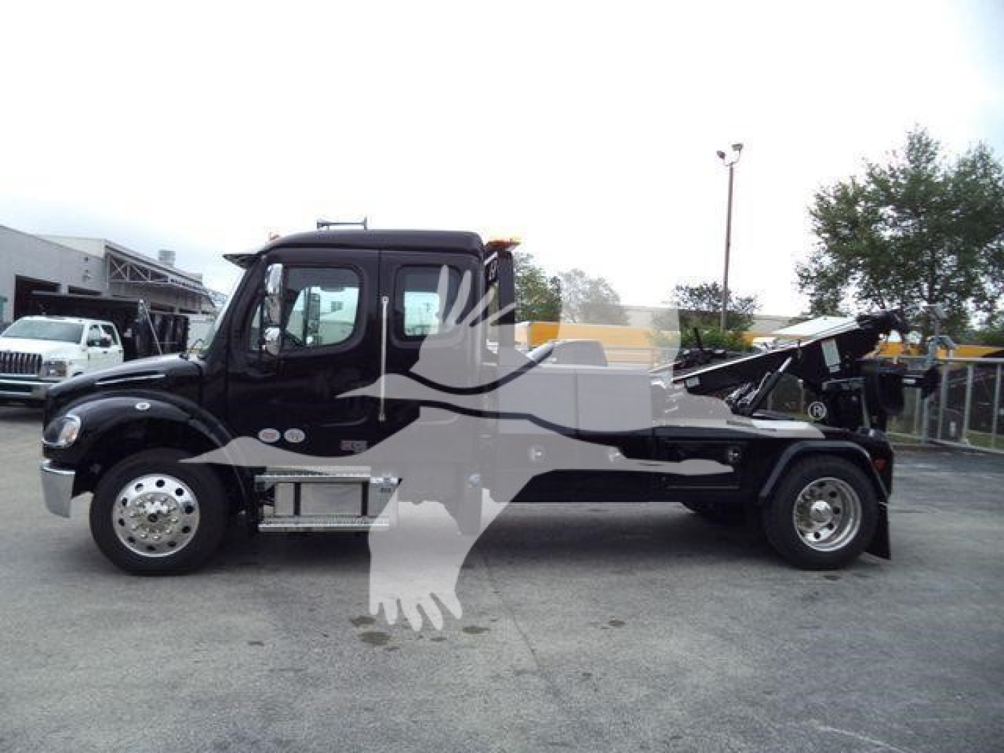Freightliner M2 106 truck with winch-equipped bed, side view showing cab, chassis, and wheels.