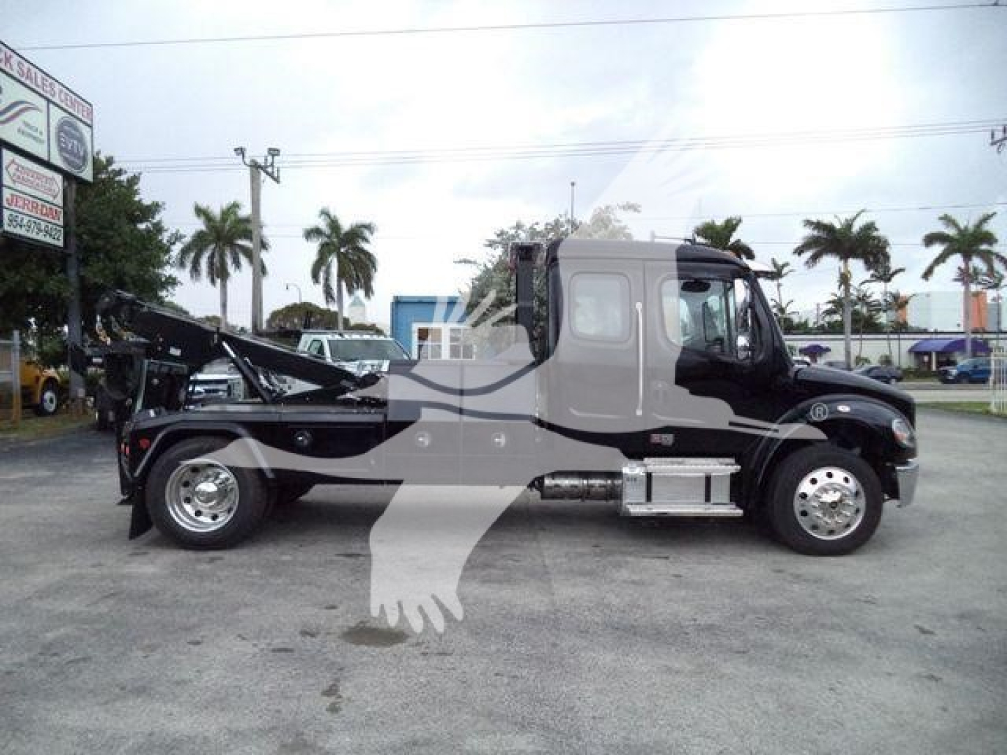 Freightliner M2 106 truck side profile showing winch equipment and service body in black with chrome exhaust and dual rear wheels.