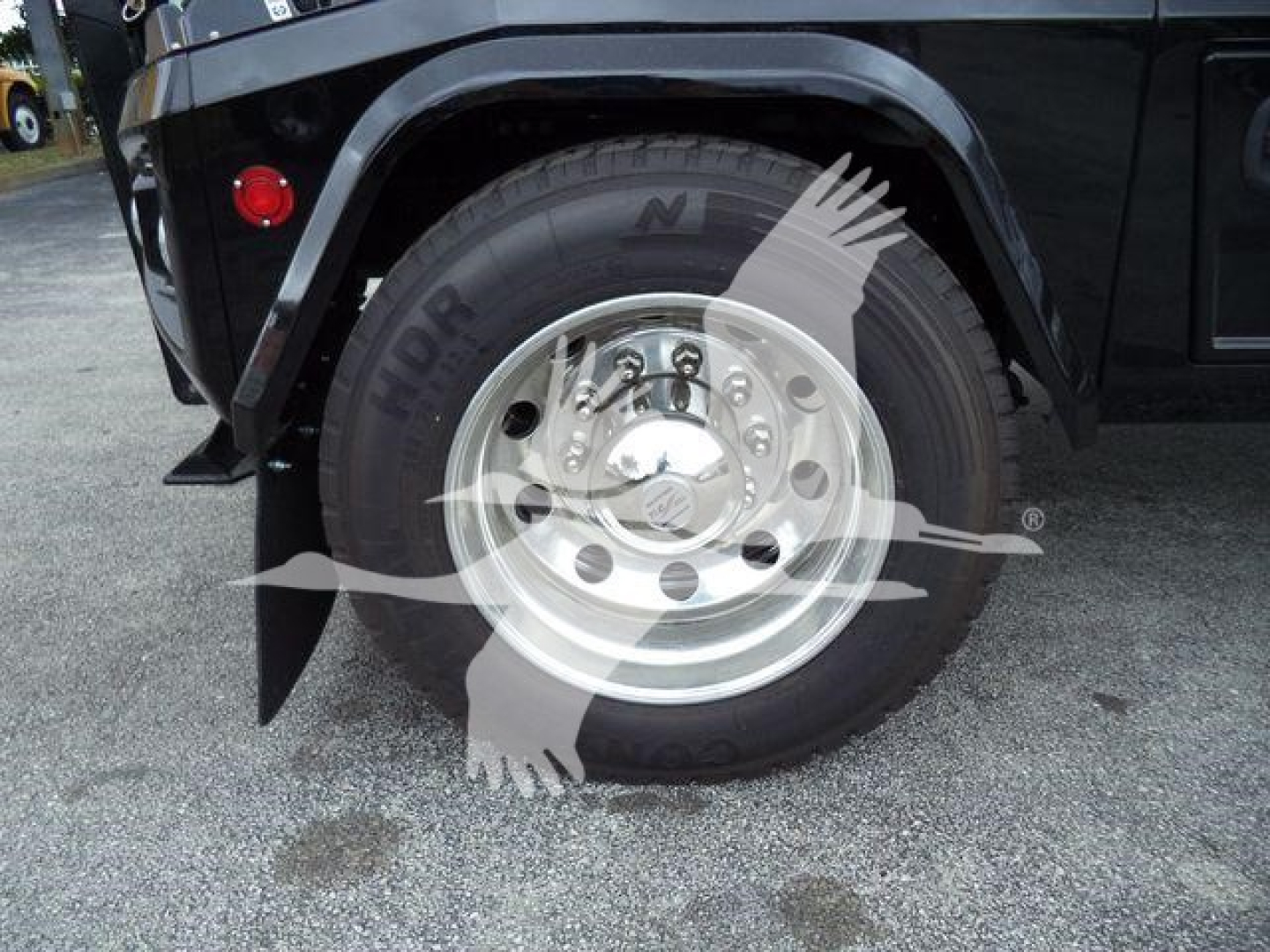 Truck wheel and fender view showing tire with 'NDR' on sidewall and polished aluminum rim; wheel well and body panel around.