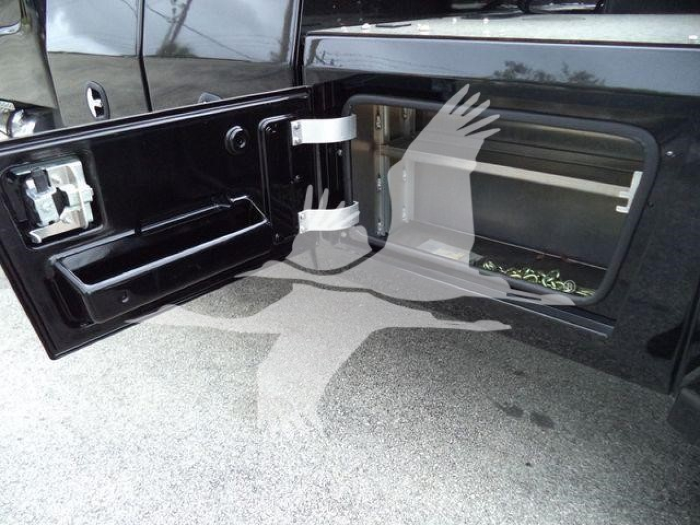 Freightliner M2 106 truck bed area showing side storage and winch compartment with open access door.