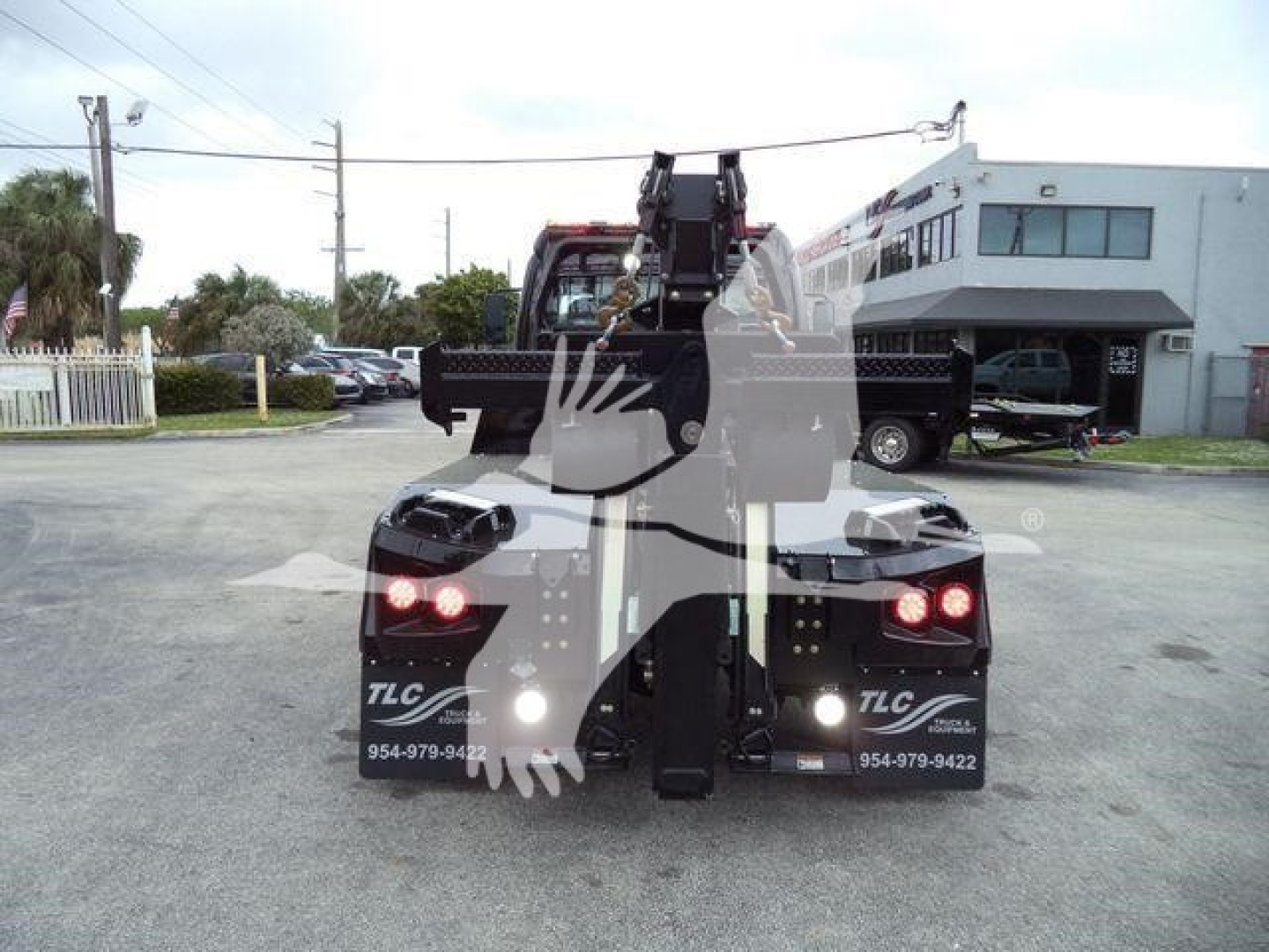 Freightliner M2 106 winch truck rear view showing tow hitch and hydraulic winch assembly.