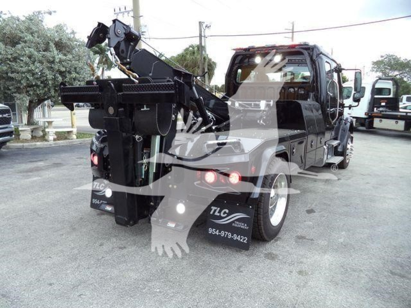 Freightliner M2 106 tow truck rear view showing heavy-duty winch and crane assembly with hydraulic hooks and towing apparatus.