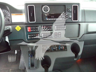 Dashboard view of a Freightliner M2 106 cabin showing center console with gauges, climate controls, and cup holders.