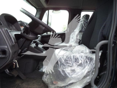 Freightliner M2 106 truck interior showing steering wheel, driver seat wrapped in plastic, and front cabin area.