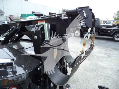 Freightliner M2 106 winch setup showing heavy-duty hydraulic winch mount and hook with safety lanyard and wiring components.