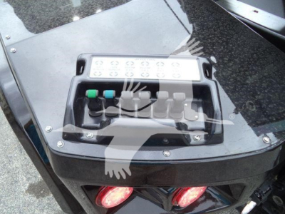 Winch control panel on Freightliner M2 106 truck in-factory housing with green/black buttons and metal latching cover.