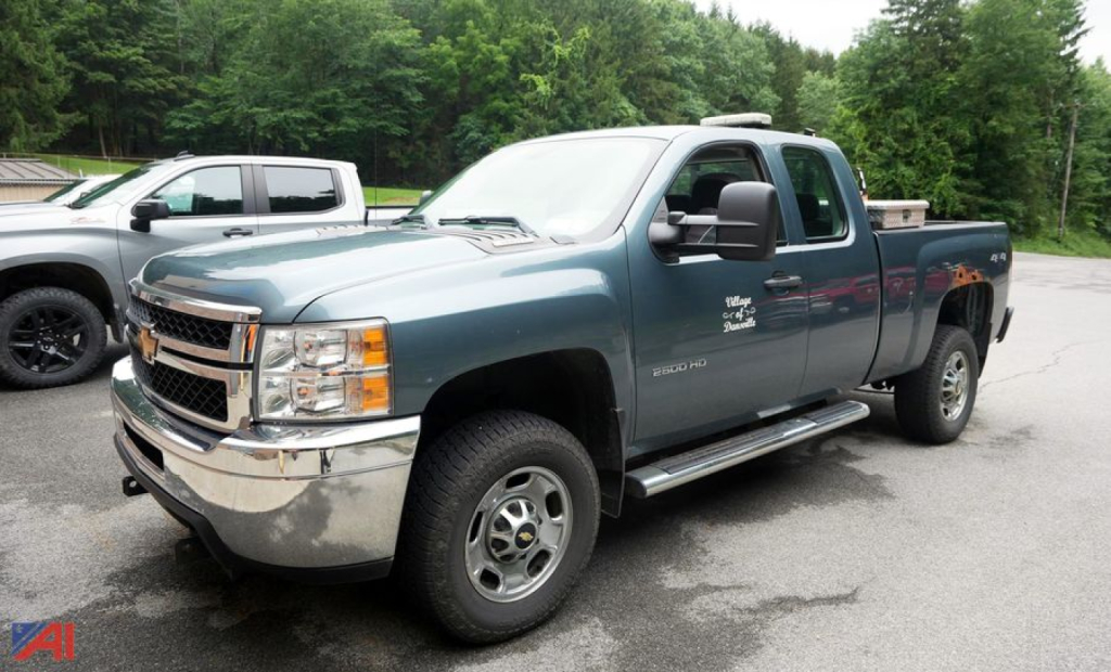 Chevrolet Silverado 2500HD extended cab with plow showing front grille, chrome bumper, side steps, and Silverado badge.