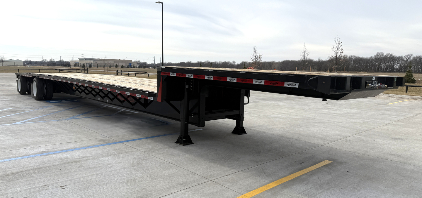 Drop deck trailer showing flatbed with support legs and black frame, 48 feet long, spread axle design.