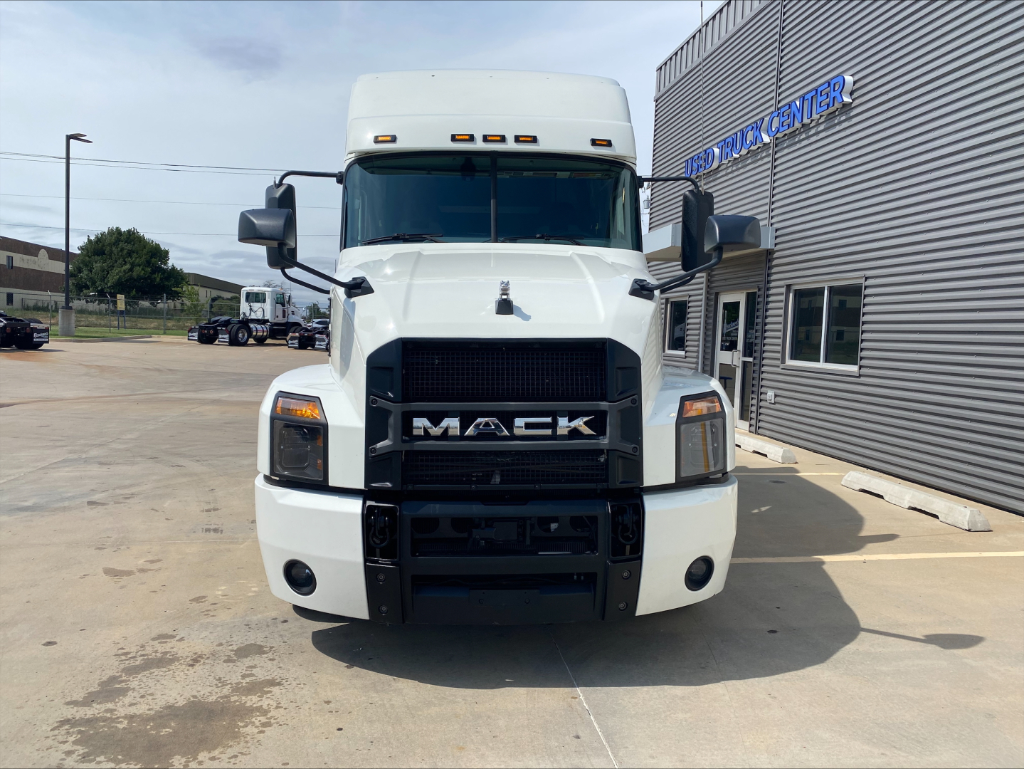 Front view of a white 2020 Mack Anthem truck showing oversized black grille with MACK badge, headlights, and bumper.