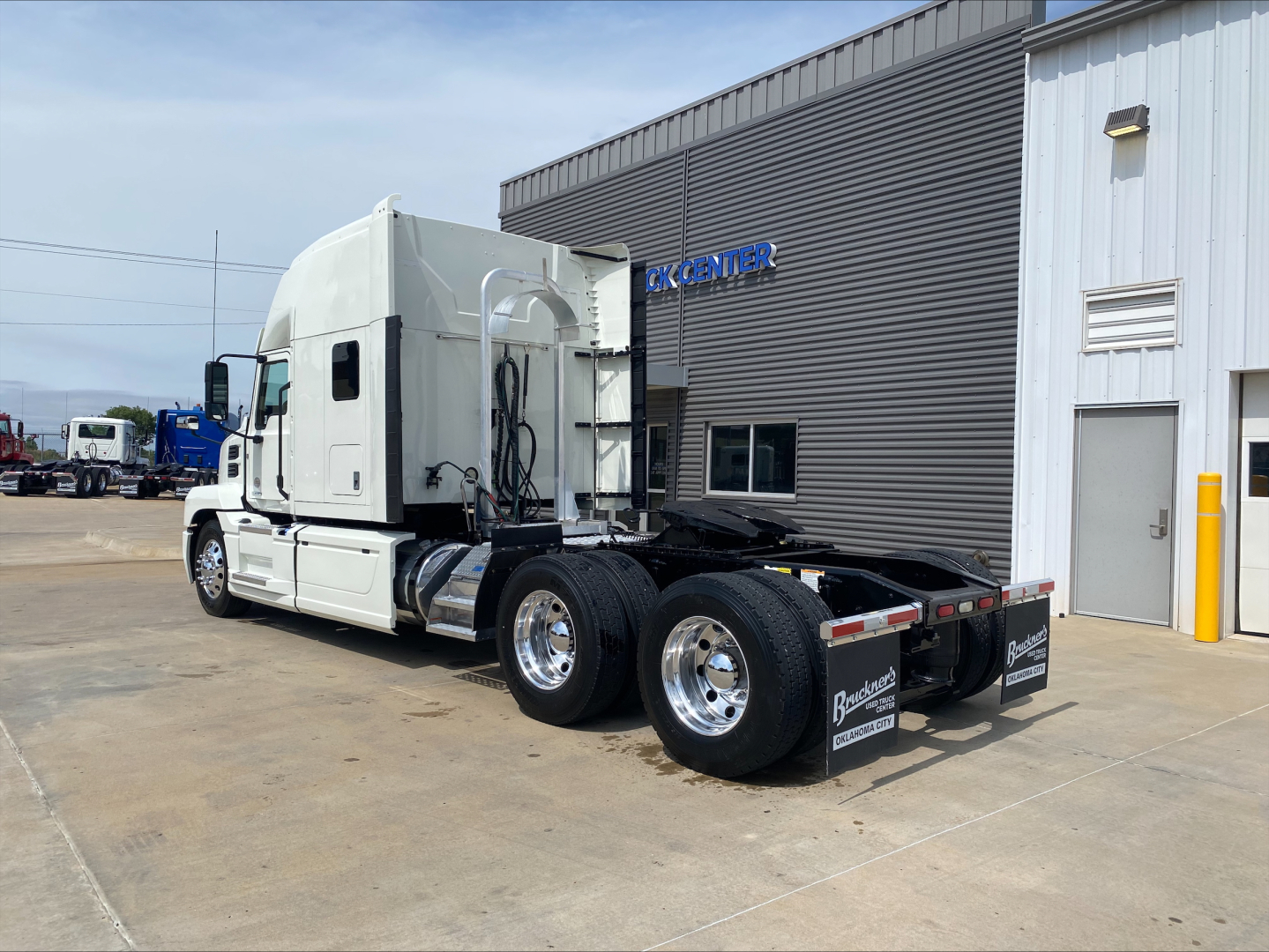 2020 Mack Anthem sleeper tractor with white cab and dual rear axles, side view, stock number plaque visible.