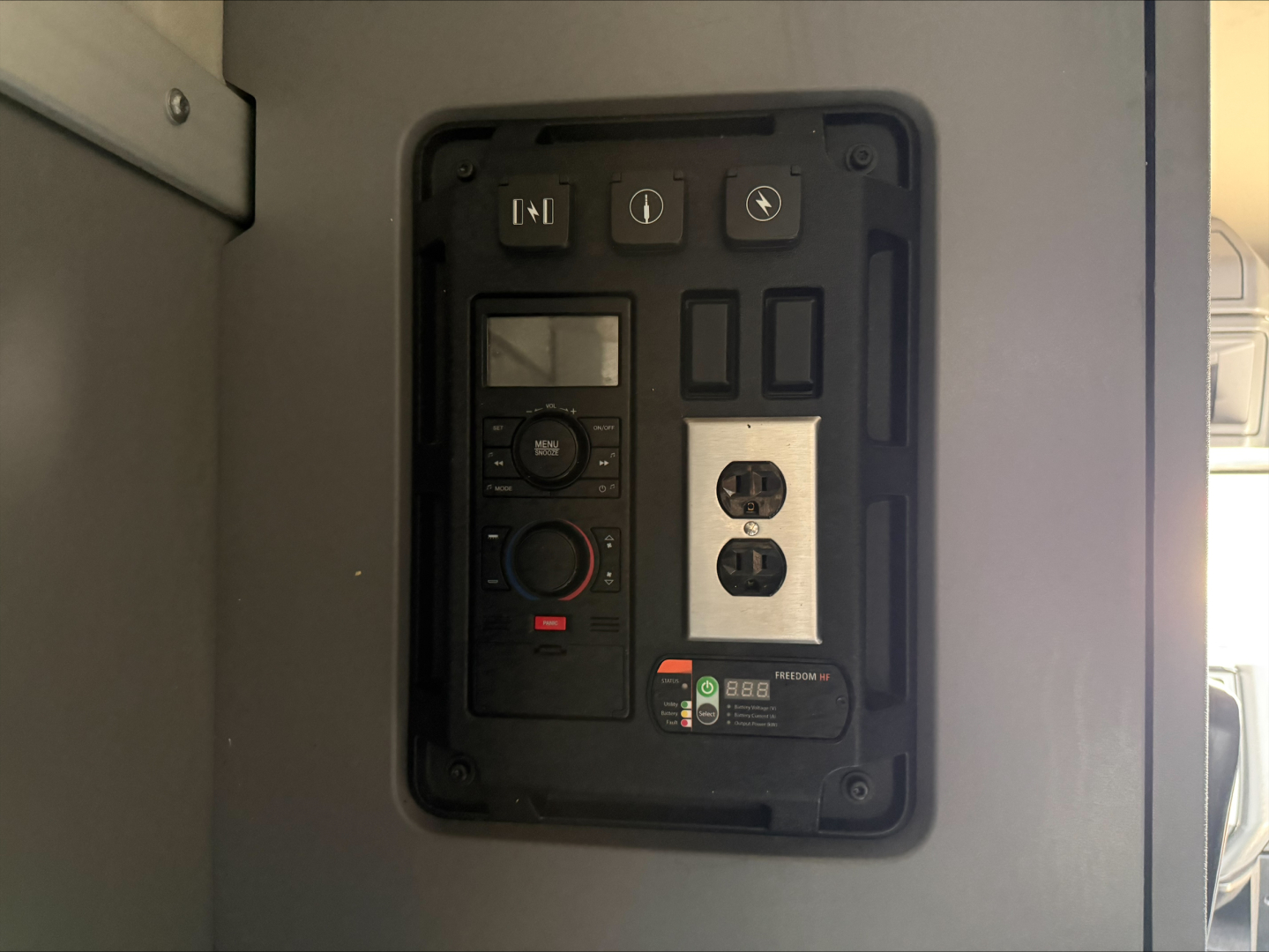 Panel with switches, gauges, and control module inside Mack ANTHEM cab side showing electrical control panel and digital display.