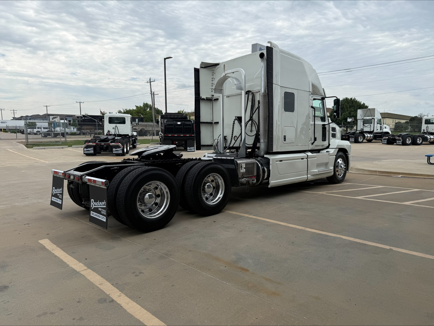 Semi truck tractor with a gray sleeper cab and rear axles in view, showing the fifth-wheel area and exhaust; no legible labels or text clearly visible on the truck body.
