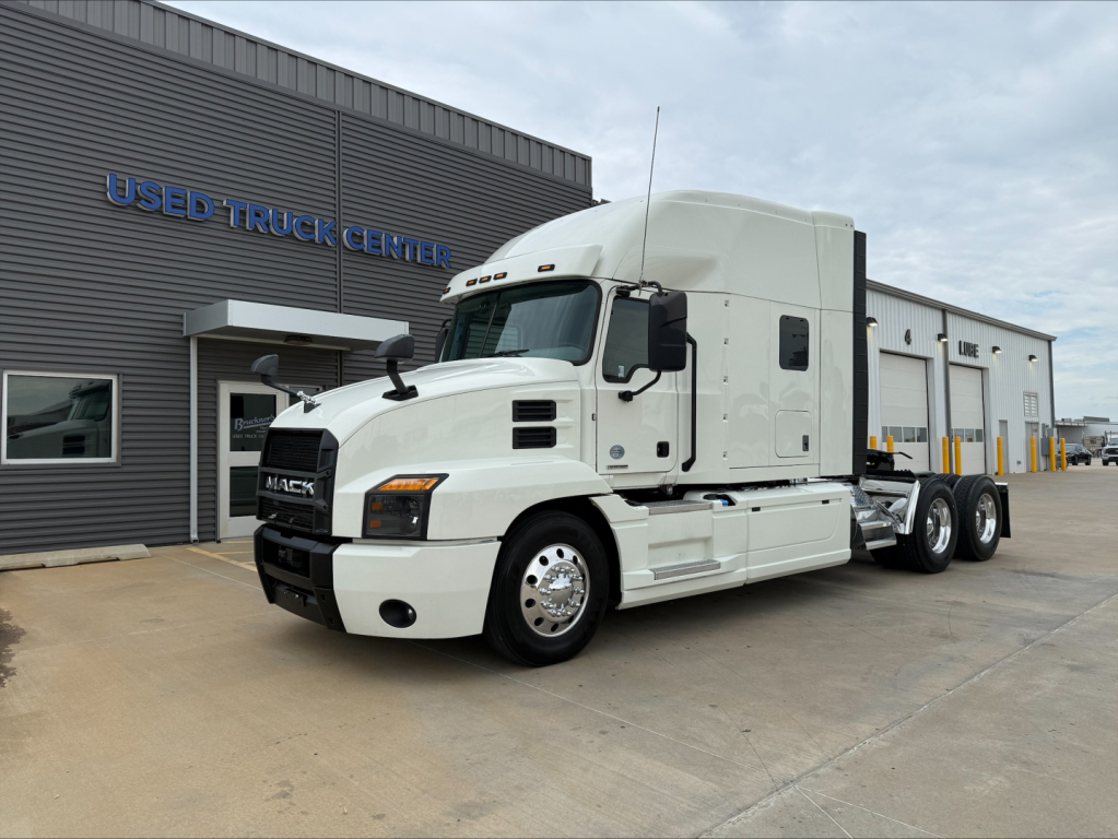 White 2020 Mack Anthem conventional sleeper truck in front of a used truck center building.