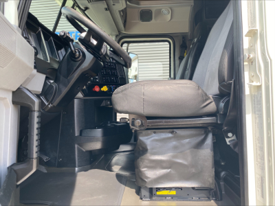 Truck cab interior of a 2020 Mack Anthem showing steering wheel, dashboard, and driver seat with base cover.