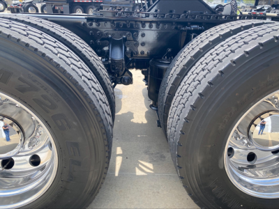 Twin rear axles of a 2020 Mack Anthem truck show dual tires and chrome wheels; chassis and suspension components visible between the wheels.