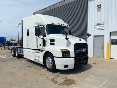Truck profile showing a white 2020 Mack Anthem Sleeper tractor in a yard, front grille with Mack logo, chrome wheels, and cab with side mirrors.