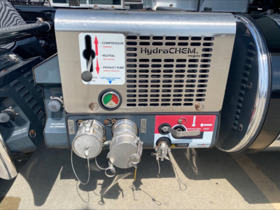 Front panel of Hydra-Compan HydraCHEM unit on a 2020 Mack Anthem showing gauges, connectors, and a control panel with labels and hoses.