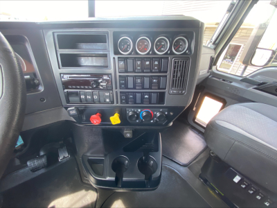 Dashboard of a 2020 Mack Anthem truck interior showing gauge cluster, switches, therapeutic controls, and cup holders.