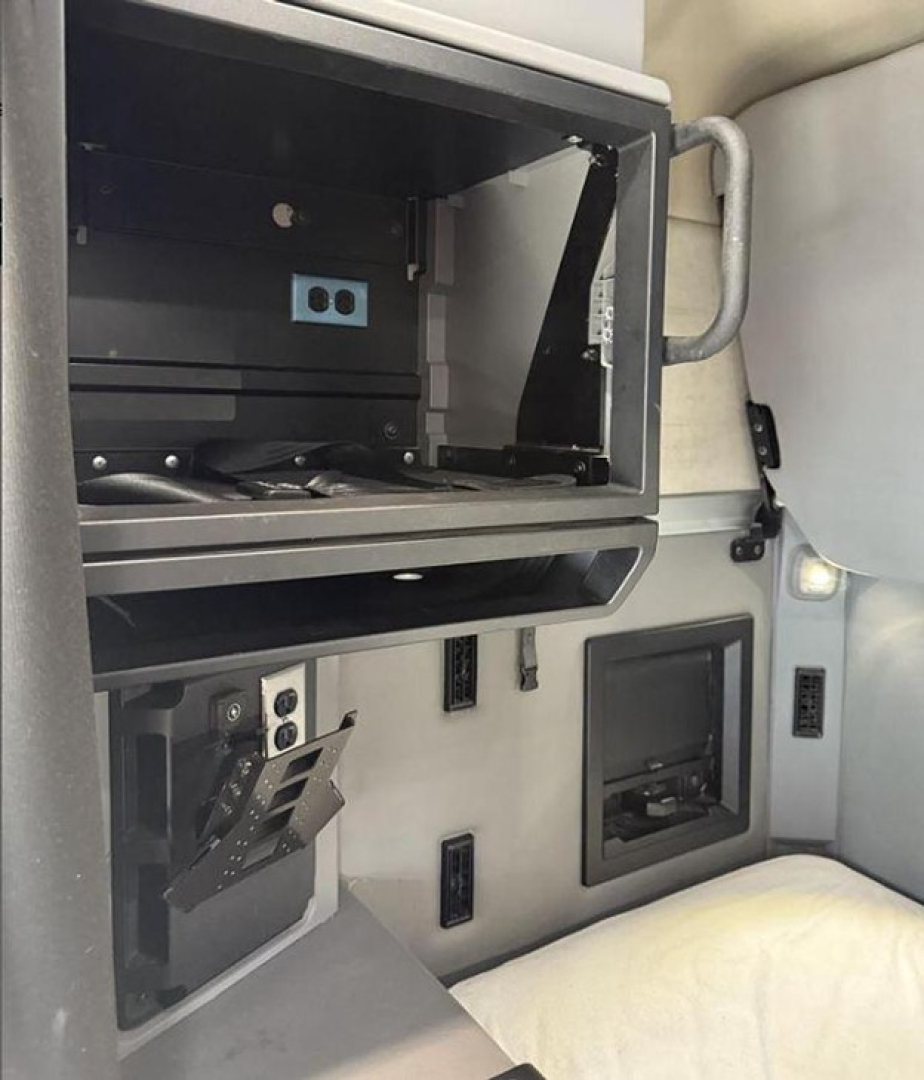 View of a Mack Anthem truck interior panel and storage areas showing open compartments and controls.