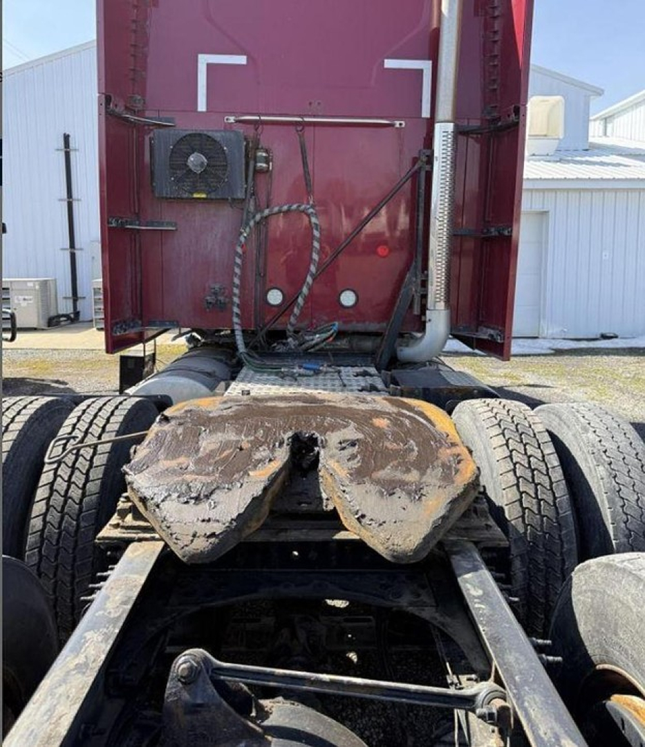 Truck rear view showing fifth wheel plate and drivetrain on a Mack Anthem tractor, with mud and wear marks on the plate area.