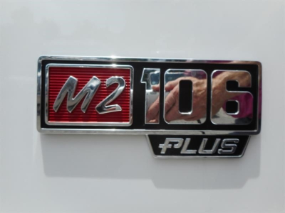 Freightliner M2 106 emblem badge on white truck panel showing M2 106 PLUS