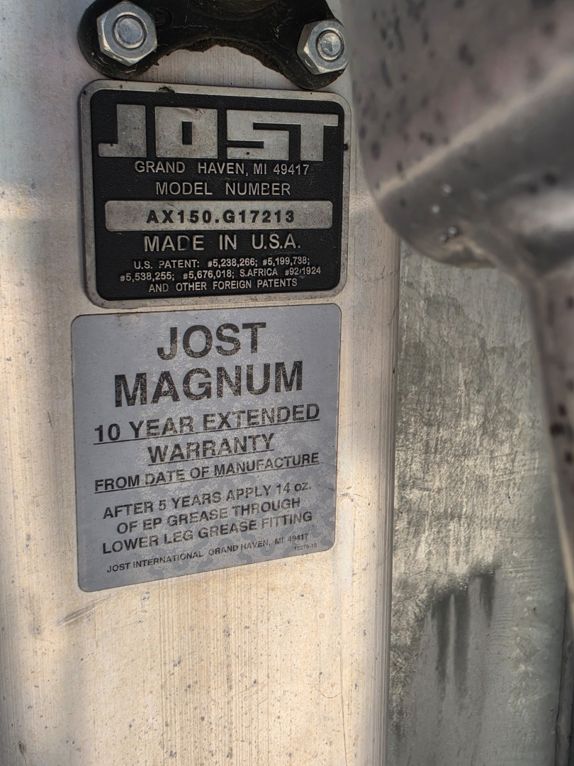 Trailer identification plate showing Jost Magnum label, model number AX150G17213, Grand Haven MI 49417, Made in USA, 10 year extended warranty.