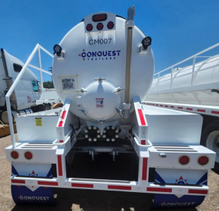 Conquest Trailers vacuum tanker rear view showing 130BBL tank with CM007 label and rear mounting with ladder and hoses.