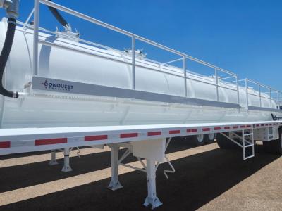 Conquest vacuum steel tank trailer side view showing 130BBL/5460 gallon capacity with ladder and support legs; Conquest branding visible on tank.