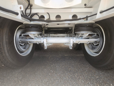 Conquest vacuum steel trailer undercarriage showing dual air springs and solid beam axle with suspension components.